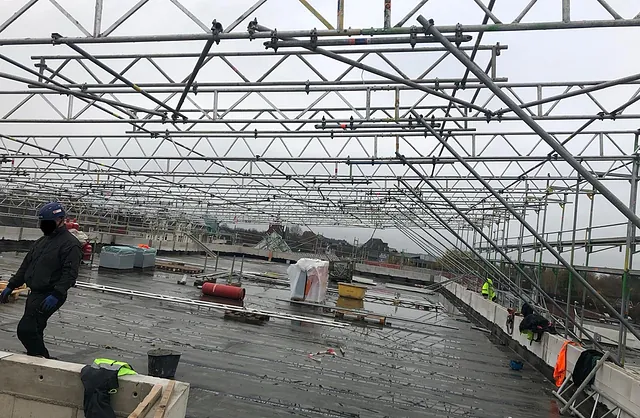 Gerüstkonstruktion aus Stahlrohren für die Montage eines großflächigen Wetterschutzdachs auf der Baustelle der Sparkasse Neumünster.